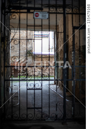 Gated Passageway Leading To Old Brick Courtyard In Weathered Urban Building Gated Passageway Leading To Old Brick Courtyard In Weathered Urban Building 135479168