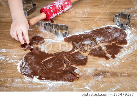Child Making Holiday Cookies With Gingerbread Dough And Festive Cutout Shapes 135479185