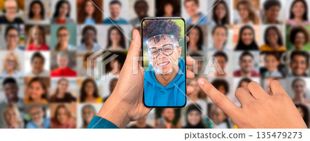 A person is engaging with a smartphone displaying a face scanning feature. 135479273