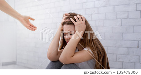 Support and care for people with mental problems. Psychologist hand helping sad lonely young woman to get rid of depression. Psychotherapy of emotional disorders, PTSD, anxiety concept 135479300