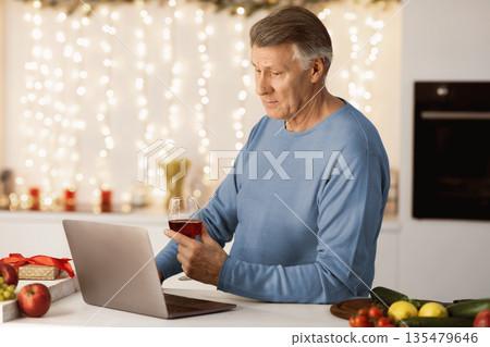 Lonely Christmas. Sad Senior Man At Laptop Making Video Call And Drinking Wine Celebrating New Year Holidays Alone At Home. Quarantine Xmas Holiday Celebration During Covid-19 Coronavirus Pandemic Lonely Christmas. Sad Senior Man At Laptop Making Video Call And Drinking Wine Celebrating New Year Holidays Alone At Home. Quarantine Xmas Holiday Celebration During Covid-19 Coronavirus Pandemic 135479646