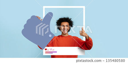 An individual expresses excitement by giving a thumbs up within a playful social media-inspired frame. The background is a soft blue, adding to the upbeat atmosphere. 135480580