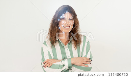 A woman stands confidently with crossed arms, showcasing the advanced facial recognition technology that identifies individuals through unique facial features. A woman stands confidently with crossed arms, showcasing the advanced facial recognition technology that identifies individuals through unique facial features. 135480730