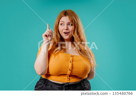 Thoughtful Body Positive Woman On Blue. Breakthrough Genius Idea. Eureka Moment, Pointing Finger up Thoughtful Body Positive Woman On Blue. Breakthrough Genius Idea. Eureka Moment, Pointing Finger up 135480766