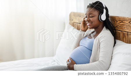 Pregnancy Leisure. Calm Black Pregnant Woman Listening Music In Wireless Headphones, African Expectant Lady Relaxing On Bed At Home, Enjoying Favorite Melodies, Side View Shot With Copy Space Pregnancy Leisure. Calm Black Pregnant Woman Listening Music In Wireless Headphones, African Expectant Lady Relaxing On Bed At Home, Enjoying Favorite Melodies, Side View Shot With Copy Space 135480792