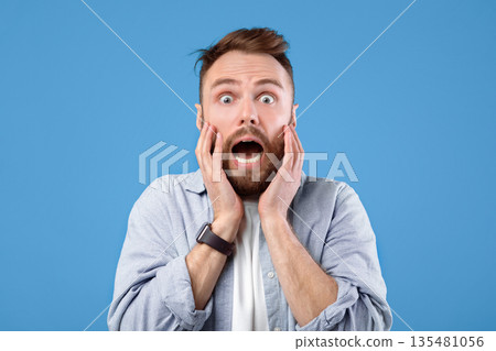 Scared young guy screaming in panic over blue studio background. Horrified bearded man feeling afraid, suffering from panic attack, yelling in fear, being dramatic Scared young guy screaming in panic over blue studio background. Horrified bearded man feeling afraid, suffering from panic attack, yelling in fear, being dramatic 135481056