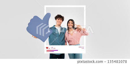 Two young influencers smile happily while posing with a thumbs-up sign, promoting online engagement and interaction. Their casual attire and cheerful expressions create a vibrant atmosphere. Two young influencers smile happily while posing with a thumbs-up sign, promoting online engagement and interaction. Their casual attire and cheerful expressions create a vibrant atmosphere. 135481078
