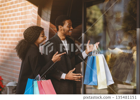 Wow, amazing clothes and low price during Black Friday and final sale. Surprised smiling young african american family with many colored packages show on showcase with huge discount, free space Wow, amazing clothes and low price during Black Friday and final sale. Surprised smiling young african american family with many colored packages show on showcase with huge discount, free space 135481151