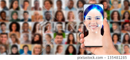 A person holds a smartphone displaying facial recognition technology. 135481285