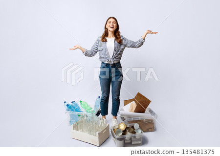 A woman stands among various recyclable materials, smiling as she promotes eco-friendly practices. 135481375