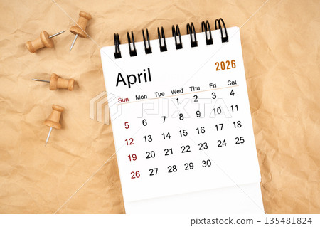 April 2026 white desk calendar with wooden thumbtack on old crumpled paper. April 2026 white desk calendar with wooden thumbtack on old crumpled paper. 135481824