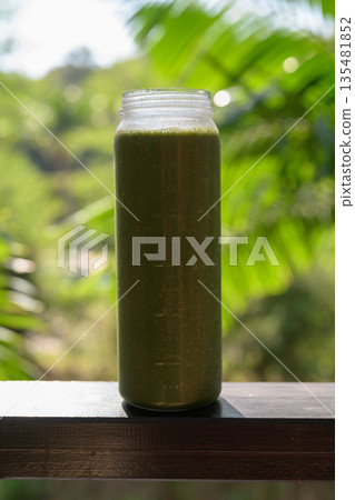 Green Smoothie Bottle with Tropical Leaves Background for Healthy Lifestyle Concept Green Smoothie Bottle with Tropical Leaves Background for Healthy Lifestyle Concept 135481852