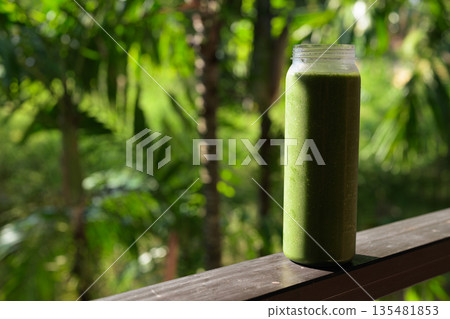 Green Smoothie Bottle with Tropical Leaves Background for Healthy Lifestyle Concept Green Smoothie Bottle with Tropical Leaves Background for Healthy Lifestyle Concept 135481853