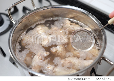 Parboiling the chicken wings and removing the scum Parboiling the chicken wings and removing the scum 135481869