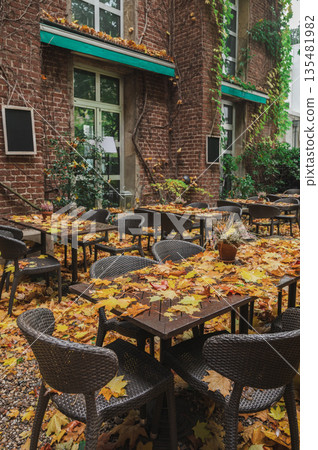 Autumn cafe with falling yellow leaves in rainy weather 135481982