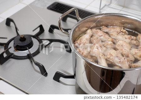 Boil the chicken wings in a pot Boil the chicken wings in a pot 135482174