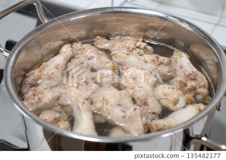 將雞翅放入鍋中煮。 135482177