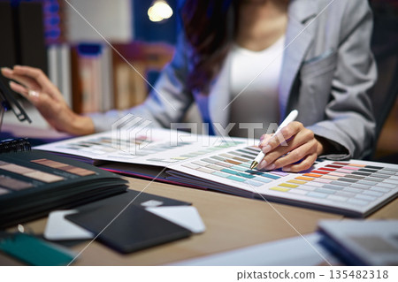 interior designer working on new house project in office. choosing materials and colors from samples 135482318