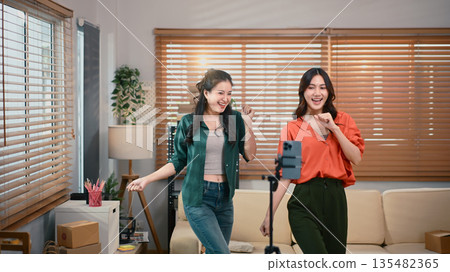 Two girl dancing and making videos for their blogs or social networks. Blogger filming vlog with online content. Two girl dancing and making videos for their blogs or social networks. Blogger filming vlog with online content. 135482365