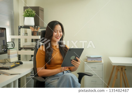 Professional female video editor editing video on his digital tablet in home office studio 135482487