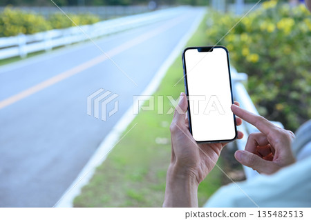 Man using smartphone in park with empty screen Man using smartphone in park with empty screen 135482513