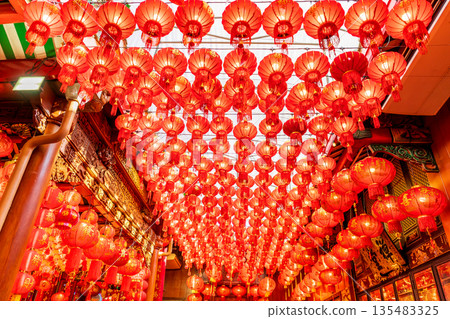 Hundreds of vibrant red Chinese lanterns hang from the ornate ceiling of Wat Mangkon Kamalawat, creating a festive spiritual atmosphere 135483325