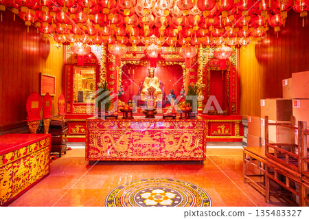 Golden Chinese-style Bodhisattva statues and ornate red interior decorations at Wat Mangkon Kamalawat during a spiritual ceremony Golden Chinese-style Bodhisattva statues and ornate red interior decorations at Wat Mangkon Kamalawat during a spiritual ceremony 135483327