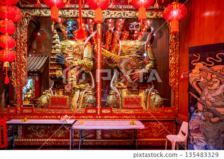 Golden Chinese-style Bodhisattva statues and ornate red interior decorations at Wat Mangkon Kamalawat during a spiritual ceremony 135483329