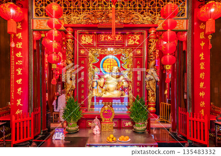 Golden Chinese-style Bodhisattva statues and ornate red interior decorations at Wat Mangkon Kamalawat during a spiritual ceremony Golden Chinese-style Bodhisattva statues and ornate red interior decorations at Wat Mangkon Kamalawat during a spiritual ceremony 135483332