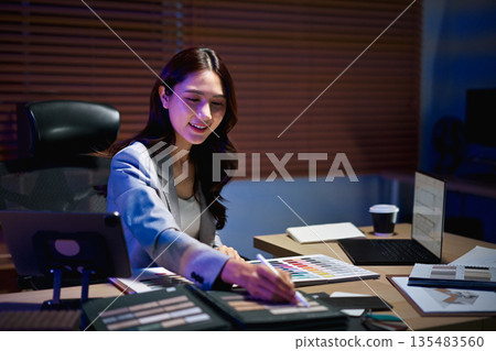 interior designer woman working on new house project in office. choosing materials and colors from samples interior designer woman working on new house project in office. choosing materials and colors from samples 135483560