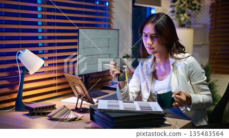 Architect interior designer working on digital tablet, choosing materials and colors from samples Architect interior designer working on digital tablet, choosing materials and colors from samples 135483564