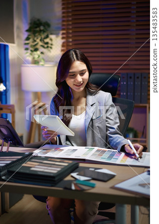 interior designer woman working on new house project in office. choosing materials and colors from calculate cost interior designer woman working on new house project in office. choosing materials and colors from calculate cost 135483583