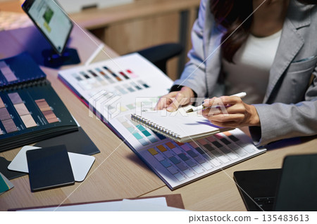 interior designer working on new house project in office. choosing materials and colors from samples 135483613