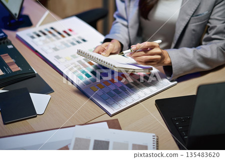 interior designer working on new house project in office. choosing materials and colors from samples interior designer working on new house project in office. choosing materials and colors from samples 135483620