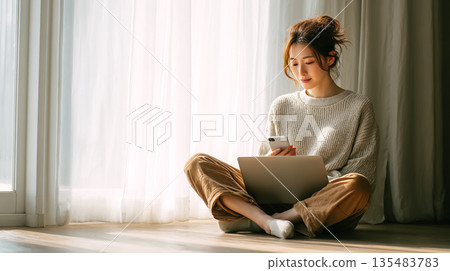 一位女士正在房間裡用電腦遠距辦公。 135483783