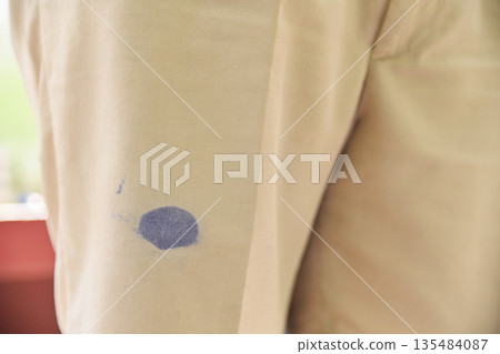 dirty blue ink stain on pants of student in school. dirty stain from cleaning concept. 135484087