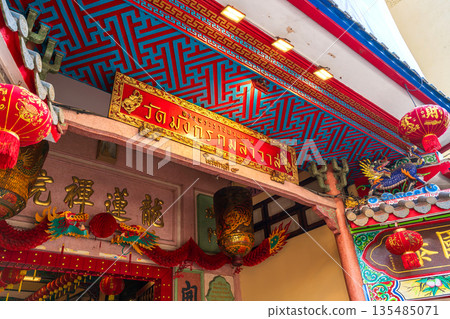 The vibrant red and gold entrance signage and traditional Chinese decorations at the main gateway of Wat Mangkon Kamalawat in Chinatown 135485071