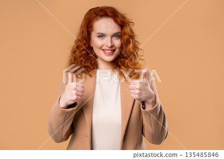 Positive Businesswoman With Hand Sign Likes, Thumbs Up Gesture. Lady on Beige Positive Businesswoman With Hand Sign Likes, Thumbs Up Gesture. Lady on Beige 135485846