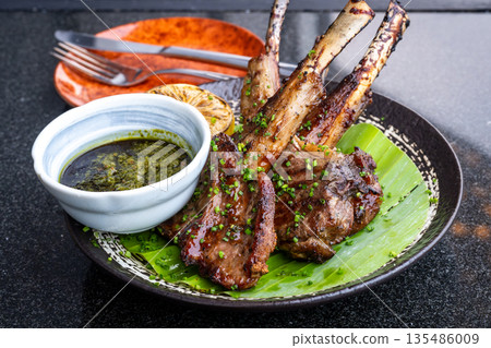 Grilled lamb chops with mint sauce served on banana leaves Grilled lamb chops with mint sauce served on banana leaves 135486009