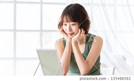 Woman checking her skin in the mirror - beauty image 135486581