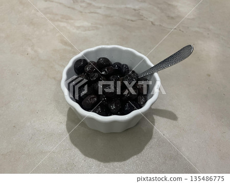 olives bowl isolated on gra table 135486775