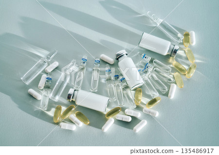 Various medical vials, ampoules, and pills on light background 135486917