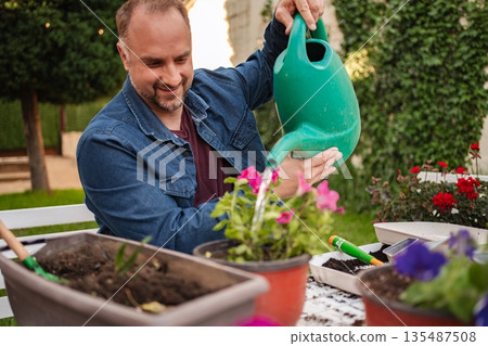 Caring for blooming flowers in a sunny garden setting Caring for blooming flowers in a sunny garden setting 135487508