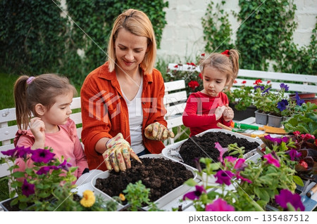 Moms and daughters gardening together in spring 135487512