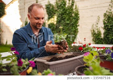 Gardening joy with potted plants in sunny garden Gardening joy with potted plants in sunny garden 135487516