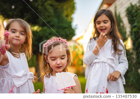 Three girls enjoying a colorful day in the garden Three girls enjoying a colorful day in the garden 135487530