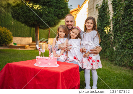 Joyful birthday celebration with family in a sunny garden 135487532
