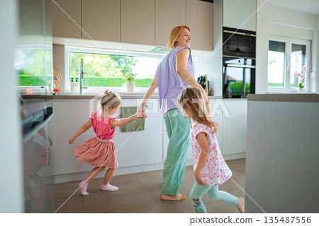Joyful moments shared in a sunlit kitchen dance Joyful moments shared in a sunlit kitchen dance 135487556