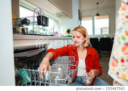 Organizing dishes in a bright and modern kitchen space 135487561