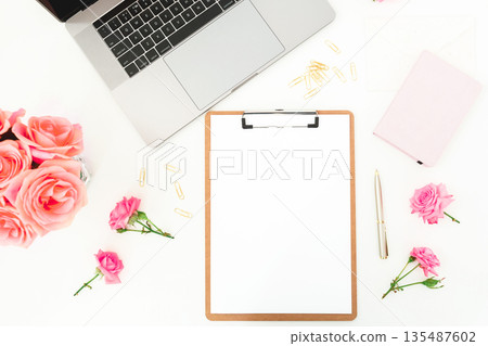 Feminine workspace with laptop, clipboard and roses on white desk, creative home office flat lay Feminine workspace with laptop, clipboard and roses on white desk, creative home office flat lay 135487602